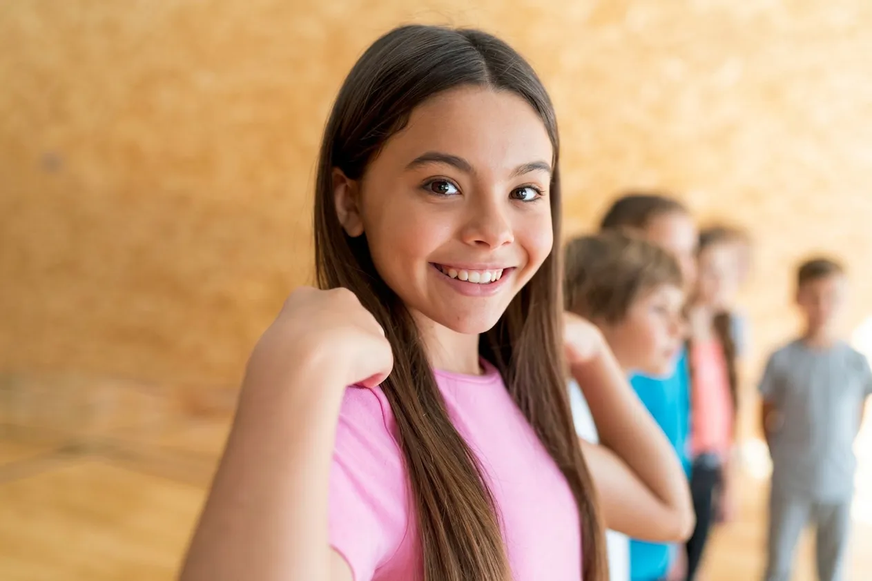 Adolescente sorrindo em quadra esportiva