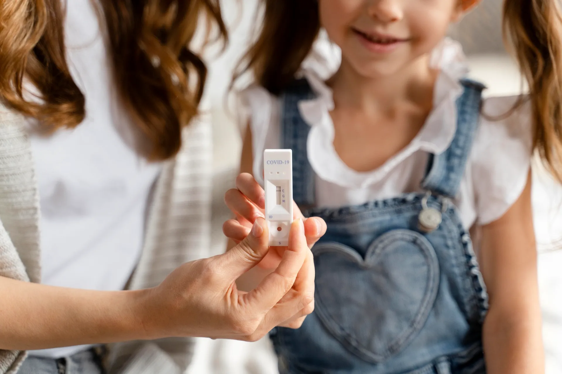 Mãe e filha segurando teste de glicose