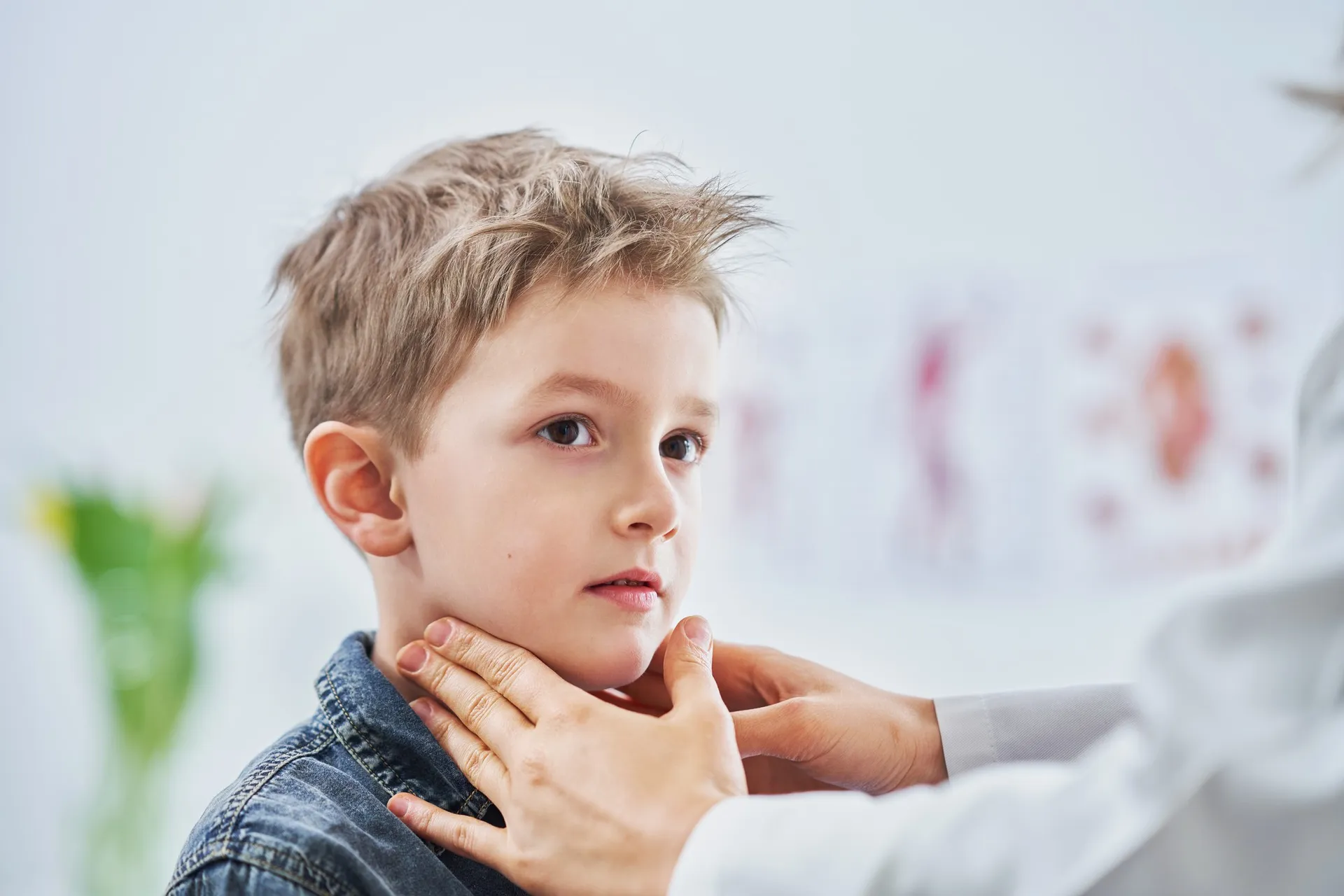 Médica examinando pescoço de menino
